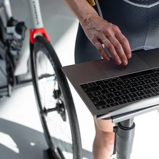 Radfahrer, der den virtuellen BKOOL Fahrradsimulator auf seinem Laptop öffnet.