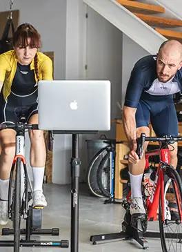 Ciclistas entrenando en casa con un simulador de indoor cycling